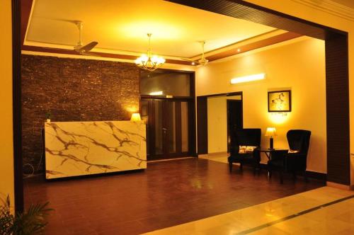 a living room with a table and a stone wall at Reina Boutique Hotel - G6 in Islamabad