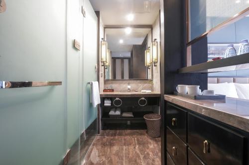 W łazience znajduje się umywalka i lustro. w obiekcie Chongqing Hilman Homeful Hotel w mieście Chongqing