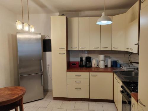 a kitchen with white cabinets and a stainless steel refrigerator at Apartment KRISTINA in Dramalj