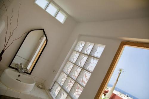un bagno con un lavandino, uno specchio e una finestra di CASTILLO LEON AGAETE ad Agaete