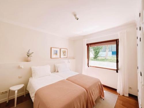 CristeloにあるJust Like Home - Casa Glóriaのベッドと窓のある白い寝室