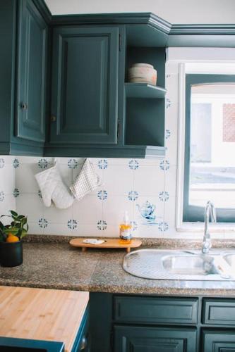 a kitchen with green cabinets and a sink at Just Like Home - Casa Glória in Cristelo