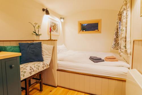 Cette petite chambre comprend un lit et une chaise. dans l'établissement Jotaferien Transylvanian Shepherdhut with jacuzzi, 
