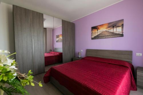 a bedroom with two red beds and a mirror at Residenza Riva Azzurra in Rimini