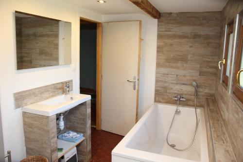 a bathroom with a bath tub and a sink at LA CHAUMIERE DE TAVOU in Cornimont