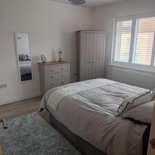 a bedroom with a bed and a dresser and a mirror at Lovely 2-Bed Apartment in Bridlington in Bridlington