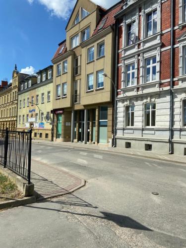 an empty street in a city with buildings at Komfortowe mieszkanie w samym centrum. in Olsztyn