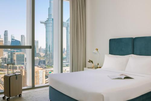 a hotel room with a bed and a large window at Sonder Downtown Towers in Dubai