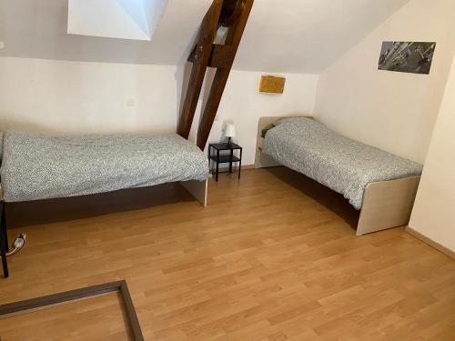 deux lits dans une chambre avec parquet dans l'établissement La Maison de Mandy, à Creissels
