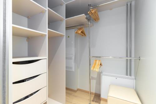a walk in closet with white cabinets and a glass door at Laulupargi Lux Residence in Tallinn