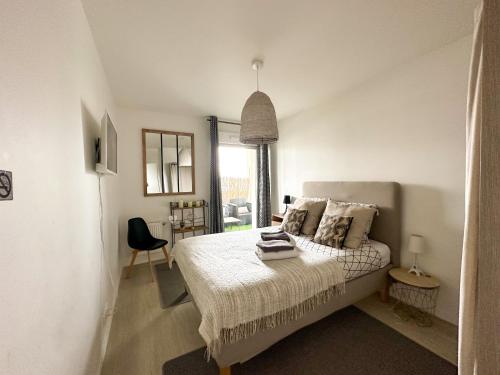 - une chambre blanche avec un lit et une fenêtre dans l'établissement Loggia Dream jacuzzi, à Montévrain