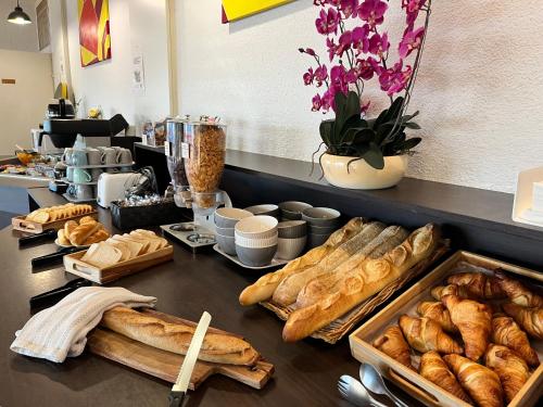 een tafel met verschillende soorten brood en gebak bij Hotel Classe Troyes - La Chapelle Saint Luc in La Chapelle-Saint-Luc