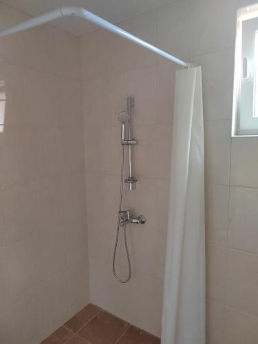 a shower with a shower curtain in a bathroom at ARIA in Primorsko