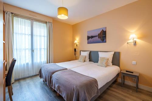 Кровать или кровати в номере Hotel Val De Loire