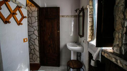 DrapiaにあるAgriturismo Casa del Contadinoのバスルーム(シンク、木製のドア付)