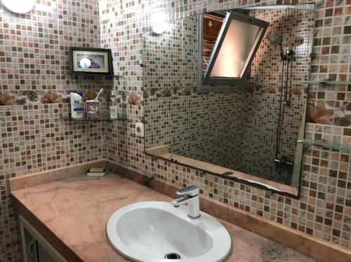 a bathroom with a sink and a mirror at 100m² avec parking gratuit proche de la plage in Mohammedia