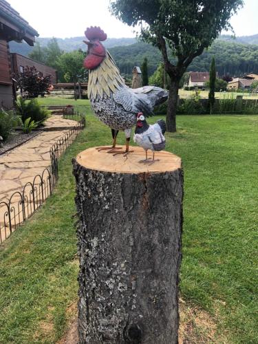 a statue of a chicken and a bird on a tree stump at Chalet Colline et Lou in Wintzfelden