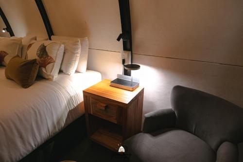 a bedroom with a bed and a chair and a table at GLAMPING SELVA IGUAZU in Puerto Iguazú