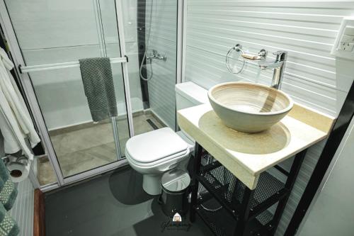 a bathroom with a bowl sink and a toilet at GLAMPING SELVA IGUAZU in Puerto Iguazú