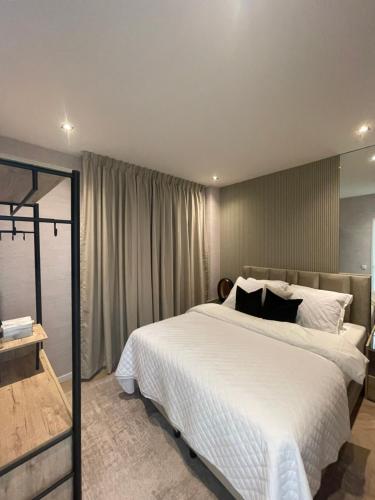 Un dormitorio con una gran cama blanca y una ventana en Centrum Hilversum appartement en Hilversum