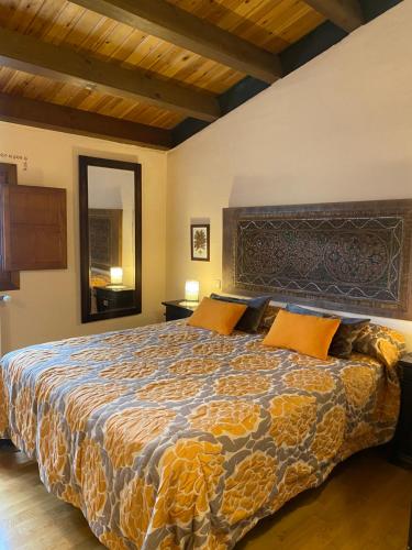 um quarto com uma cama grande e almofadas laranja em El Balcón De Alboreca em Alboreca