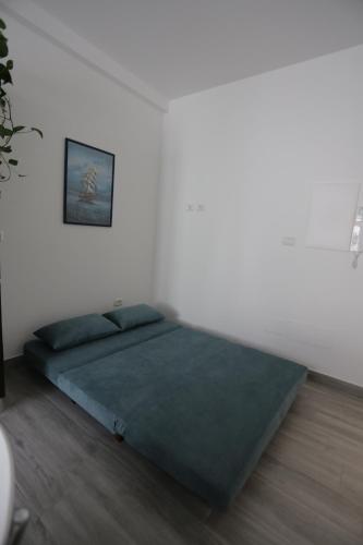 a bedroom with a green bed in a white wall at La Suite del Borgo in Bovalino Marina