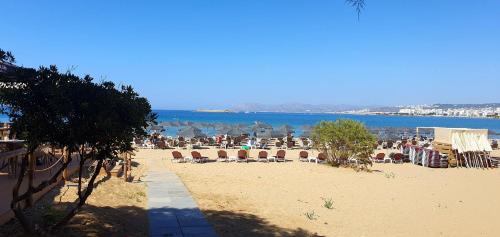 uma praia com cadeiras e guarda-sóis na areia em Perivolia Serenity in Chania em Ayiá
