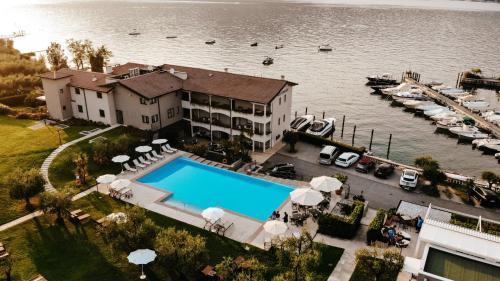 una vista aerea di una casa con piscina e porto turistico di Bella Hotel & Restaurant with private dock for mooring boats a San Felice del Benaco