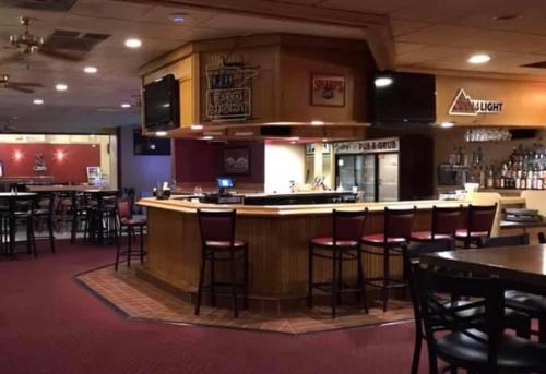 a bar in a restaurant with chairs and tables at Crookston Inn & Convention Center in Crookston
