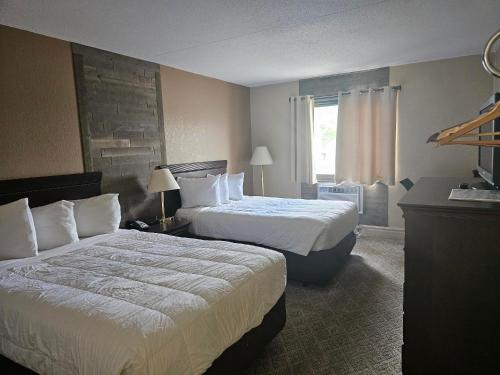 um quarto de hotel com duas camas e uma janela em Crookston Inn & Convention Center em Crookston