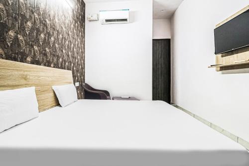 sypialnia z łóżkiem i telewizorem na ścianie w obiekcie OYO Prime Property w mieście Ludhiana