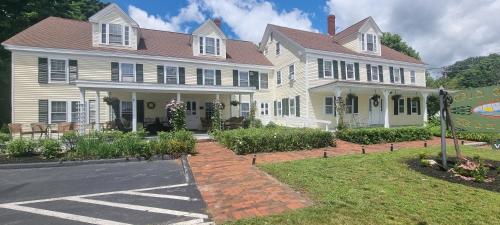 une grande maison blanche avec un panneau devant elle dans l'établissement Old Orchard Beach Inn, à Old Orchard Beach