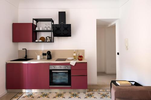 a kitchen with purple cabinets and a stove at Savadè Cefalù in Cefalù