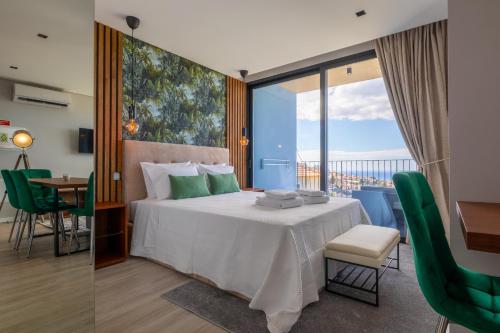 um quarto de hotel com uma cama, uma mesa e cadeiras em Atlântico Azul no Funchal