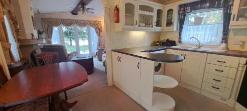 a small kitchen with a table and a sink at Namelis po beržais in Marijampolė