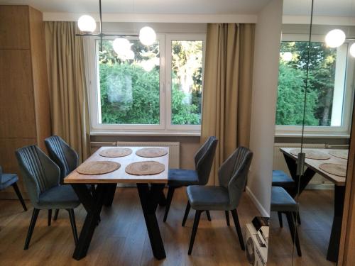 comedor con mesa, sillas y ventana en Apartament Górka Zdrój en Busko-Zdrój