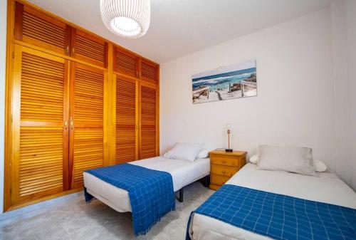 two beds in a room with wooden cabinets at Villa Teram in Alajeró