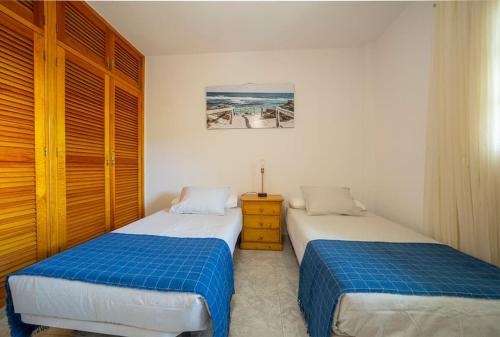 a bedroom with two beds and a dresser in it at Villa Teram in Alajeró