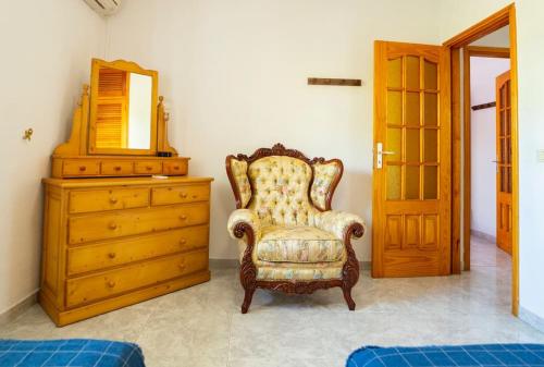 a room with a chair and a dresser and a mirror at Villa Teram in Alajeró