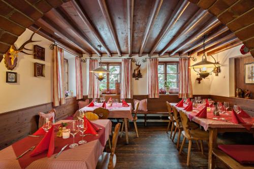 un restaurant avec des tables, des chaises et des serviettes rouges dans l'établissement Refugio Laudegg, à Ladis