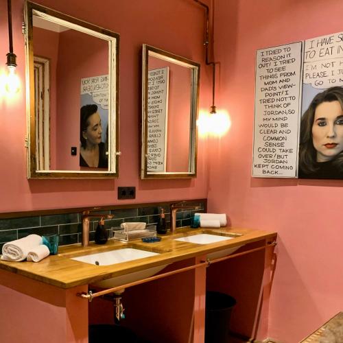a bathroom with two sinks and two mirrors at Brody House - boutique hotel in Budapest