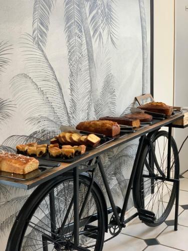 ein Tisch mit Brot und Gebäck auf einem Fahrrad in der Unterkunft Manoir De Rigourdaine in Plouër-sur-Rance