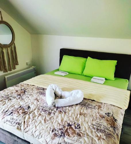 a bed with two towels on it with green pillows at Apartman Boba Vrnjačka Banja in Vrnjačka Banja