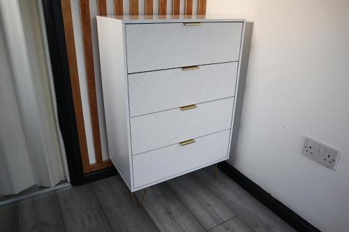 a white cabinet with four drawers in a room at 259A Queen Ediths Way in Cherry Hinton