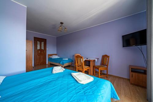ブワディスワボボにあるMikoのベッドルーム(青いベッド1台、テーブル、椅子付)