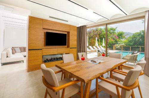 a dining room with a table and a fireplace at Likya Gardens Hotel in Kas
