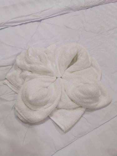 a white towel on top of a bed at NST Boutique เอ็นเอสทีบูทีค in Ban Pak Phun