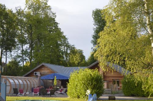 a log cabin with tables and chairs in front of it at Le Village de la Champagne - Slowmoov in Bar-sur-Aube