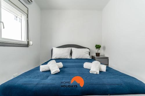 a bedroom with a blue bed with towels on it at #183 Private Terrace Oldtown with AC in Albufeira