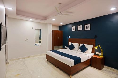 a bedroom with a bed with a blue wall at OYO SILVERKEY EXECUTIVE RC Near ISKCON Temple Noida in Indirapuram